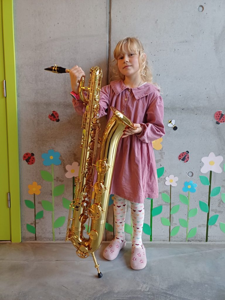 meitene tur rokās baritona saksafonu