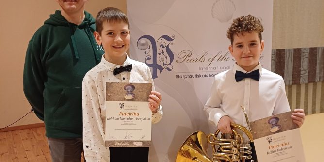 abi laureāti kopā ar skolotāju