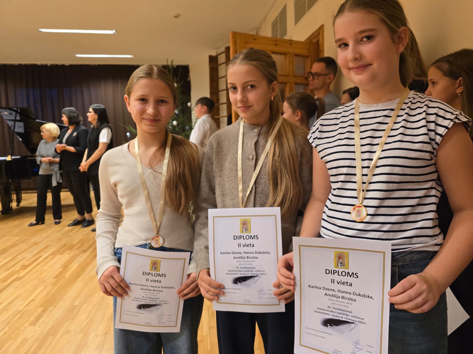 attēlā ar diplomiem klavieru trio meitenes