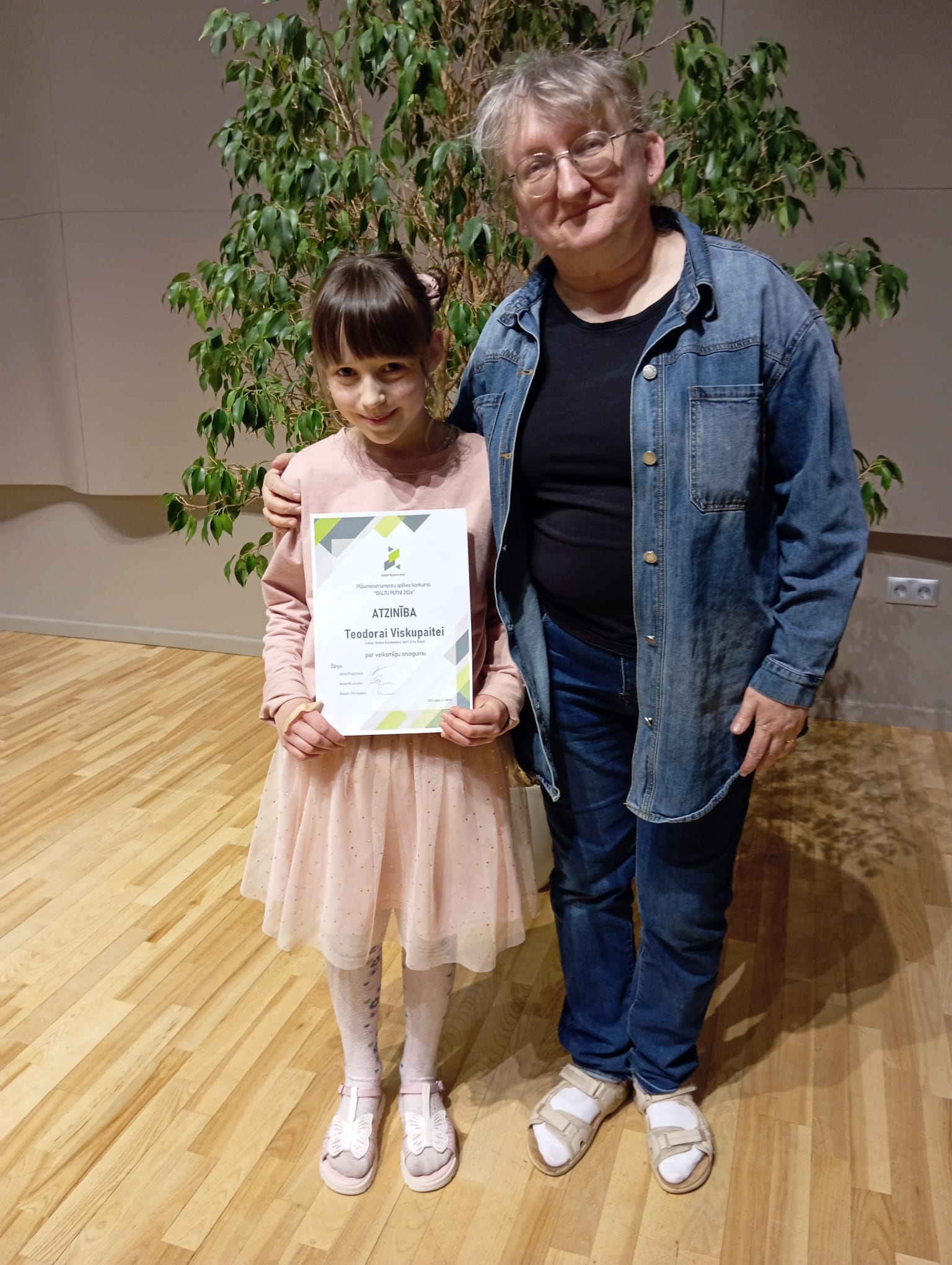 Mūsu pedagoģe kopā ar audzēkni. Audzēknei rokās iegūtais diploms.