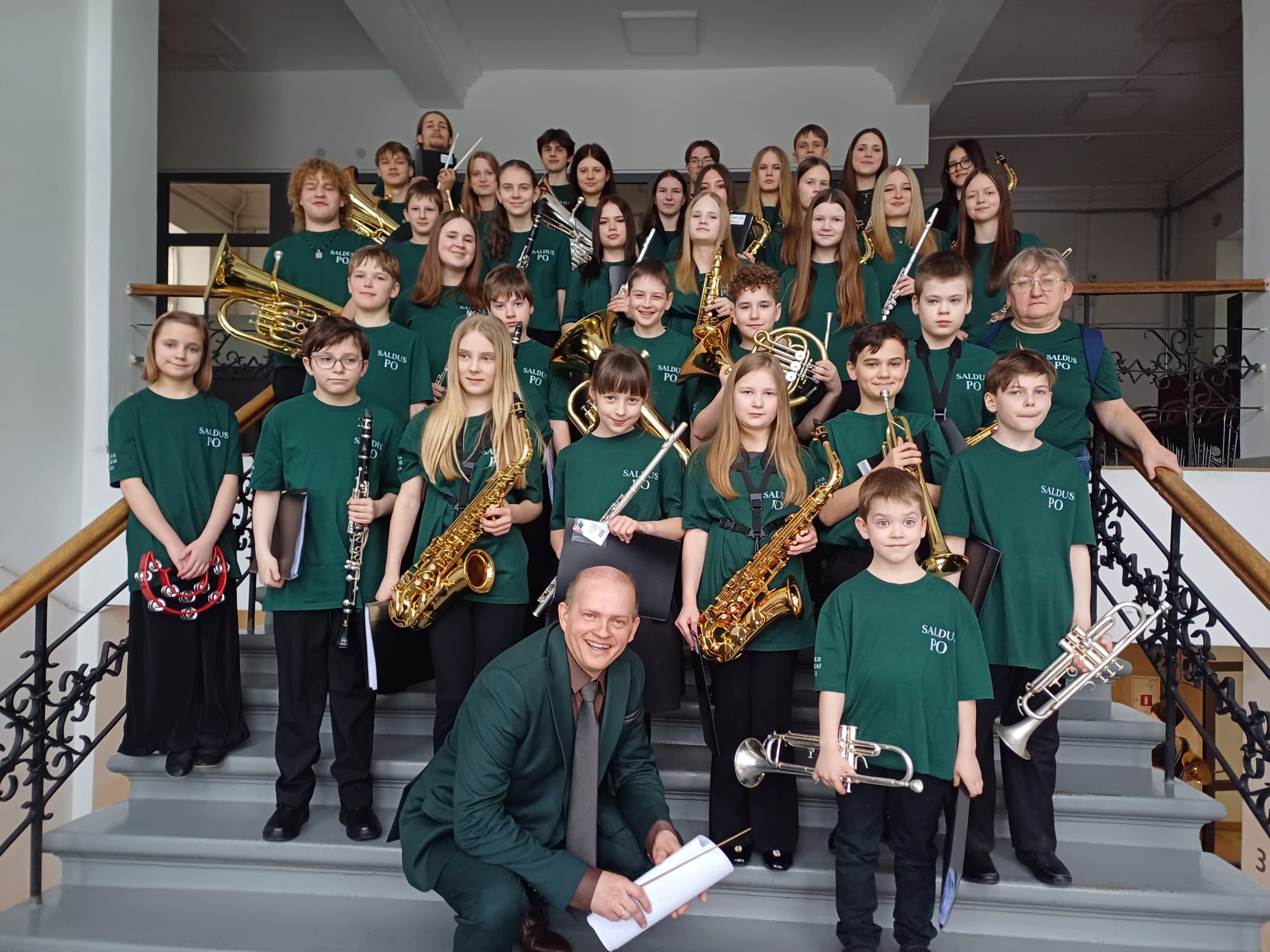 kopbildē - mūsu pūtēju orķestris kopā ar diriģentu - uz kapnēm, turot rokās savus instrumentus.